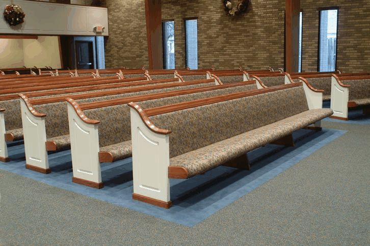 Close-up of worn church pew surfaces showing damage from daily use